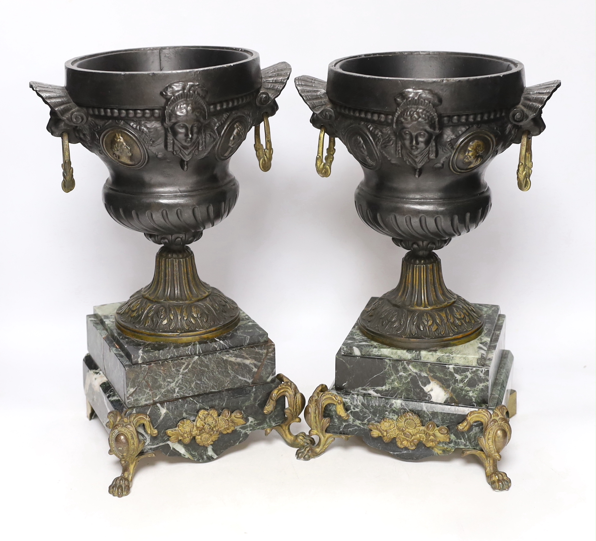 A pair of late 19th century French gilt metal and brown patinated urns, decorated with masks and serpentine plinths, 33cm high